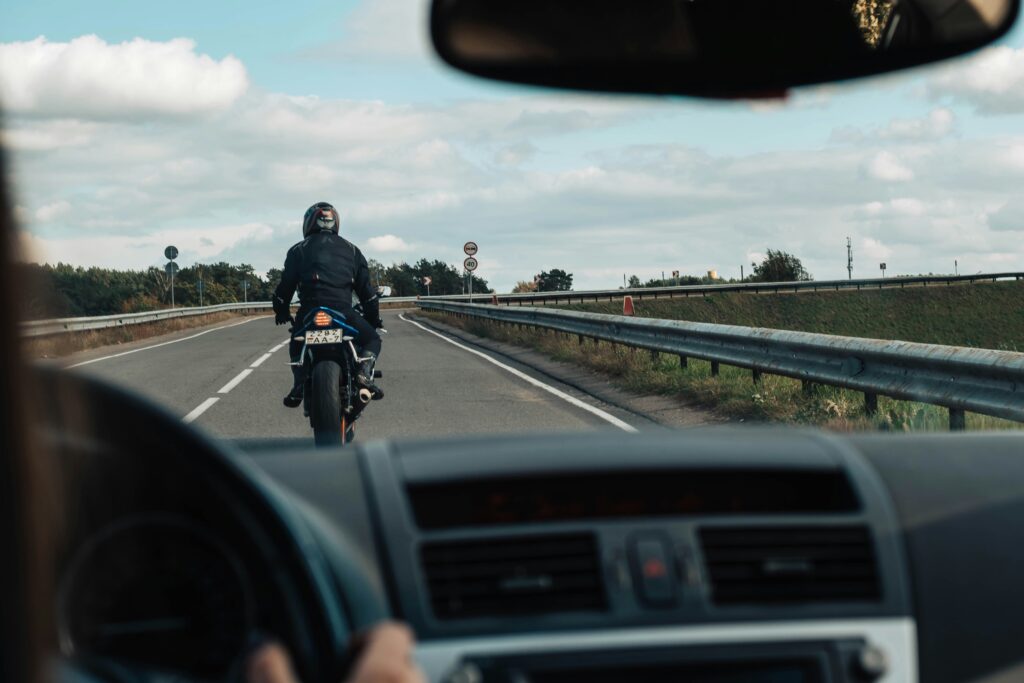 View from a car following a motorcycle on a highway – illustrating visibility and safety concerns in motorcycle accidents compared to car accidents in Las Vegas.