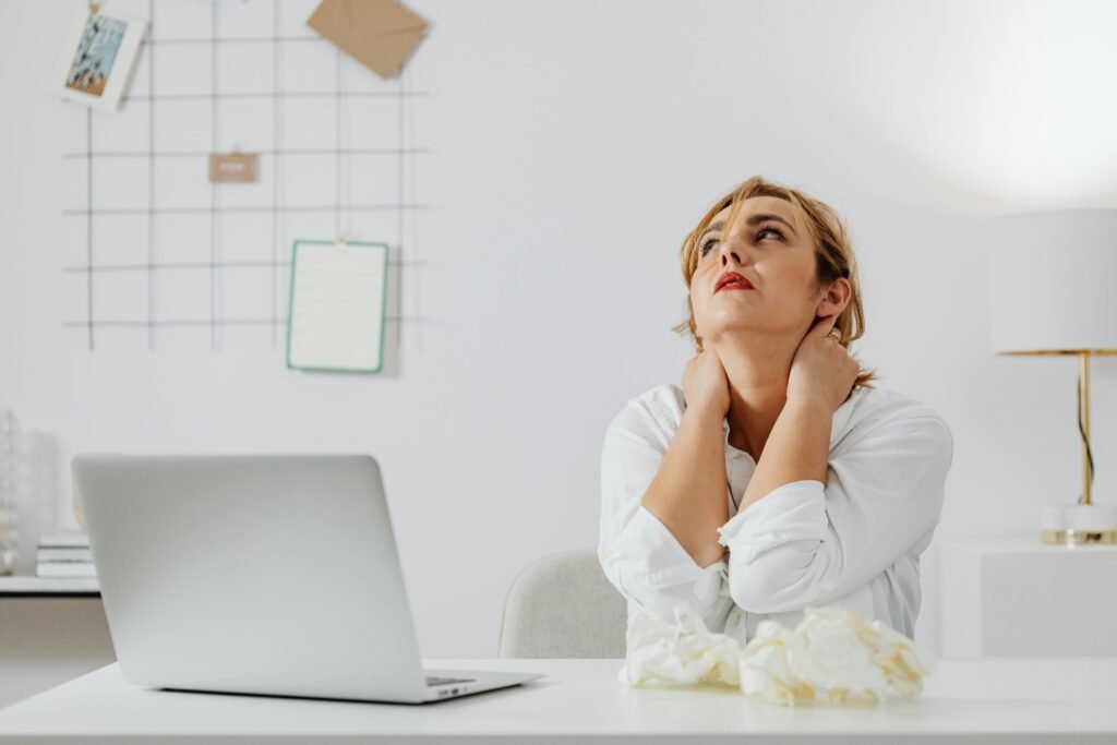 A stressed woman sitting at her desk, overwhelmed by the challenges of handling a pro se personal injury case.
