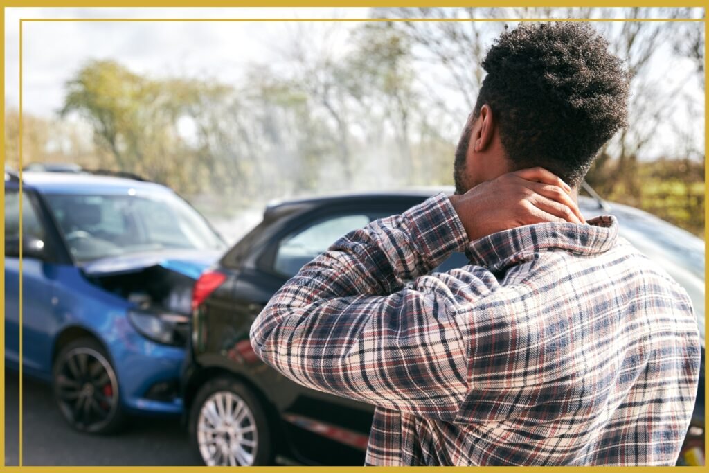 Man holding his neck while observing a car accident, illustrating pain and the importance of knowing what to do when you're not at fault.