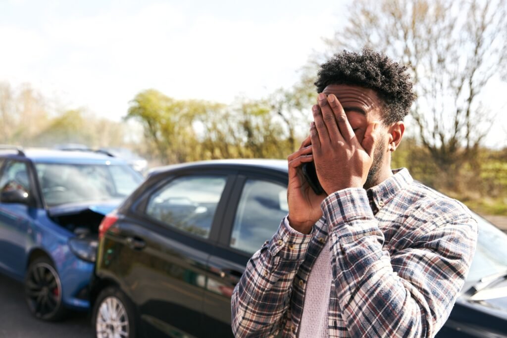 Stressed driver calling the police after a car accident, taking the proper steps when they are not at fault.