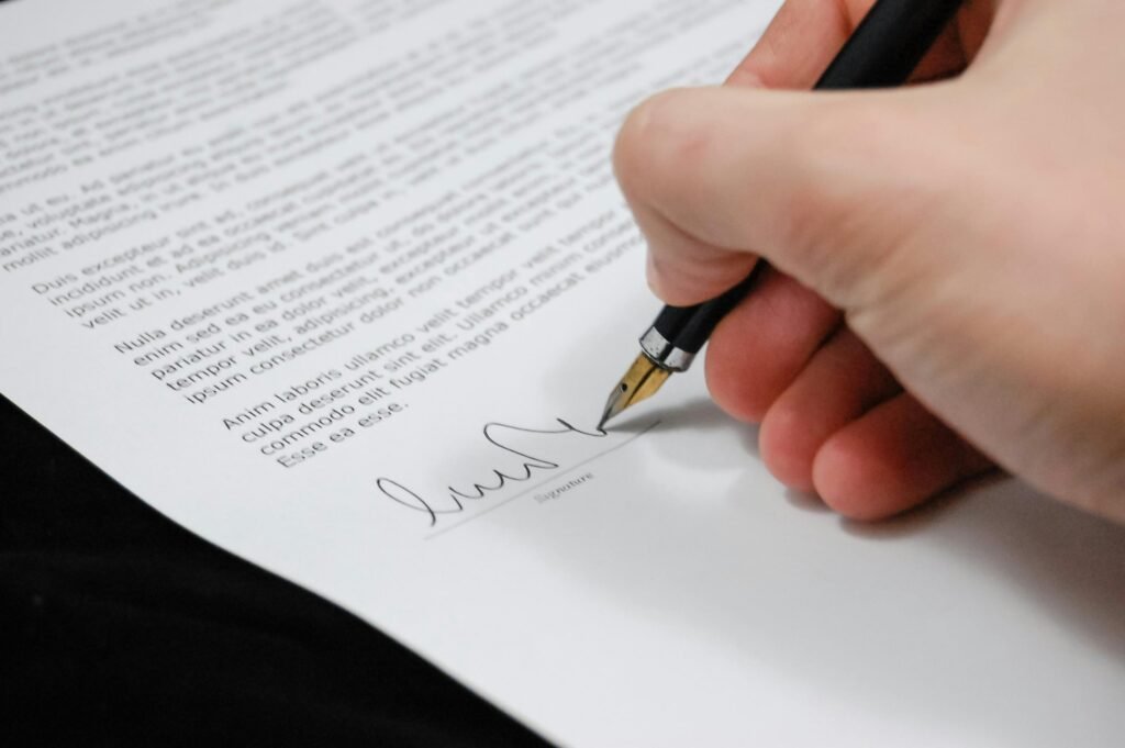 Person signing paperwork related to a personal injury settlement agreement.