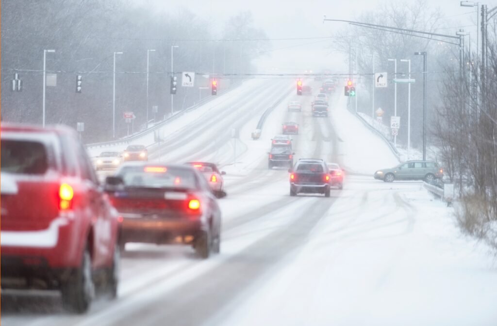 Low visibility driving conditions on a winter road, emphasizing winter driving tips for safe travel in fog, rain, or snow.