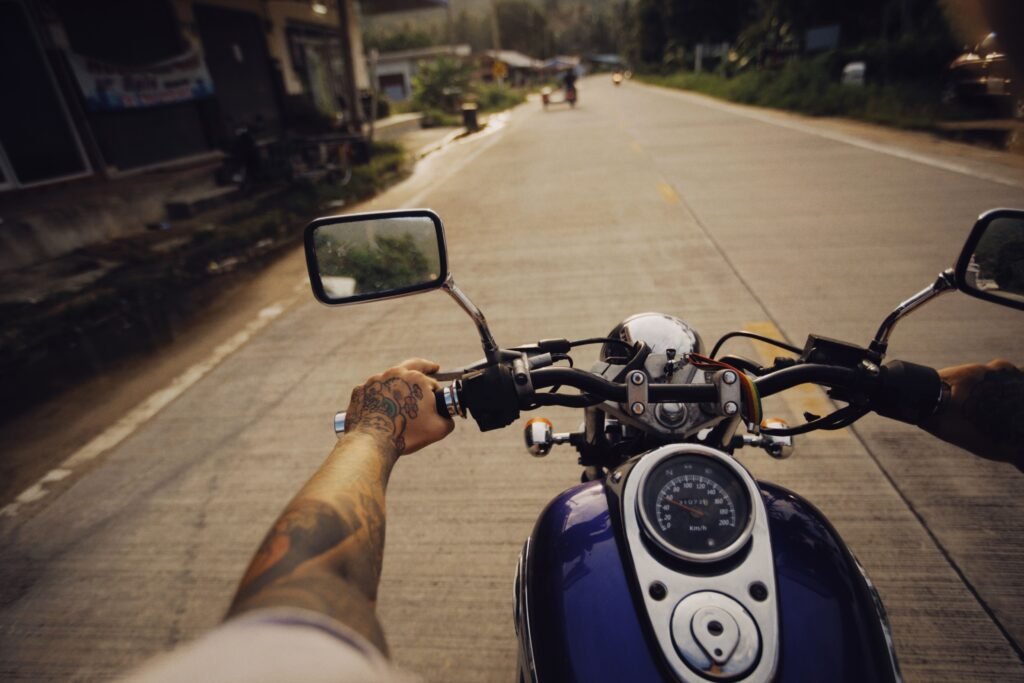 Motorcyclist standing beside a damaged motorcycle after a crash on a Henderson roadway, highlighting why an experienced motorcycle accident lawyer in Henderson can help injured riders pursue compensation.